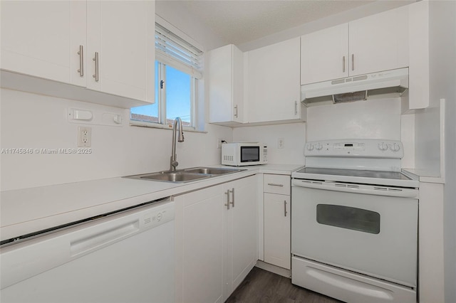 kitchen featuring under cabinet range hood, white appliances, a sink, and light countertops