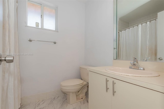 bathroom with toilet, marble finish floor, baseboards, and vanity