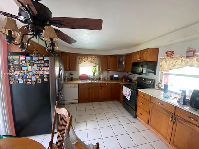 kitchen featuring sink, black appliances, and light tile patterned flooring