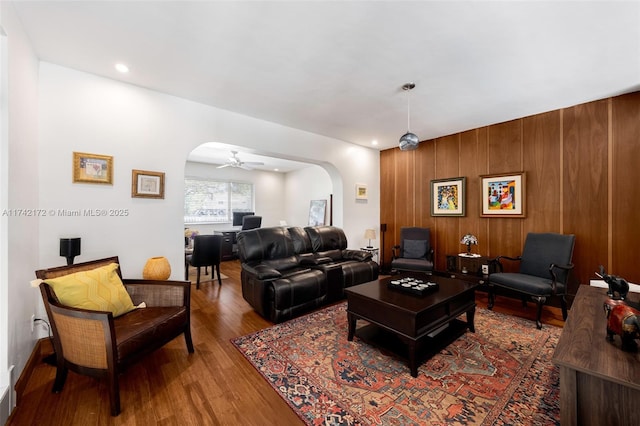 living room with wood-type flooring and wooden walls