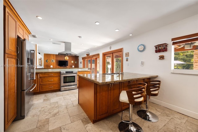 kitchen with ventilation hood, appliances with stainless steel finishes, a kitchen breakfast bar, and kitchen peninsula