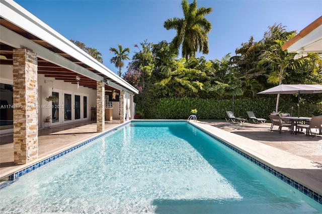 view of pool with a patio, ceiling fan, and french doors