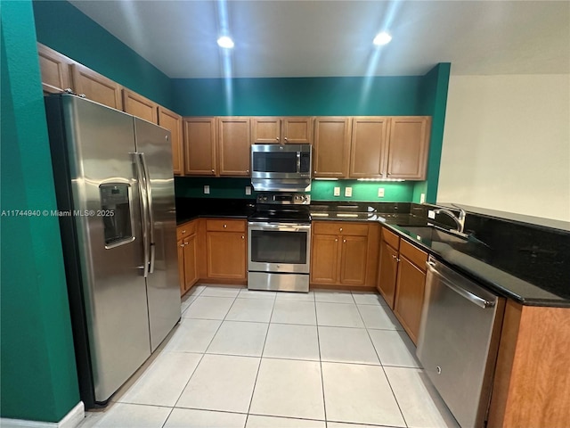 kitchen featuring light tile patterned flooring, appliances with stainless steel finishes, sink, and kitchen peninsula