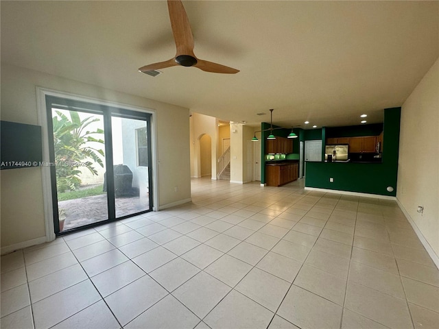 unfurnished living room with light tile patterned floors and ceiling fan