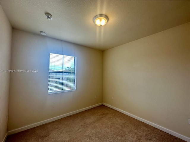 carpeted empty room with a textured ceiling