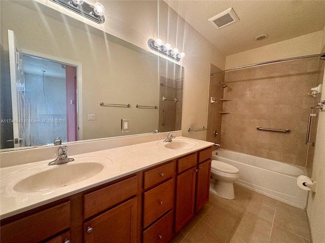 full bathroom featuring tile patterned floors, vanity, toilet, and tiled shower / bath combo