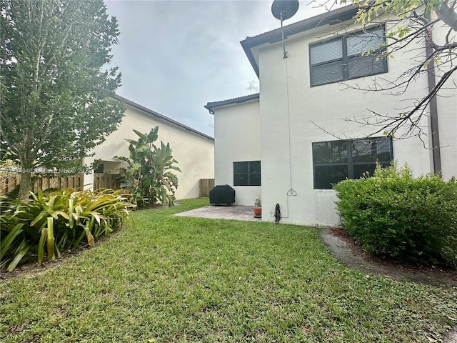 back of house with a patio and a lawn