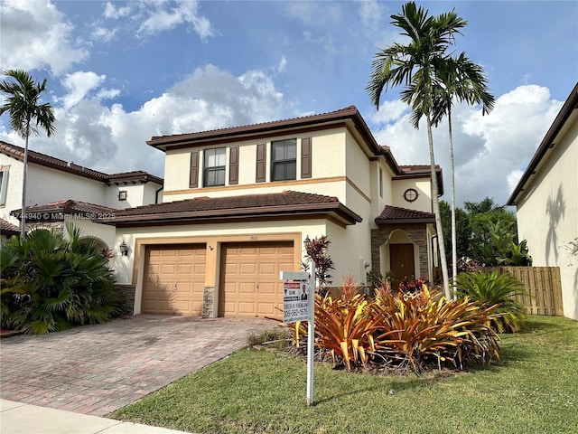 mediterranean / spanish home featuring a garage and a front yard