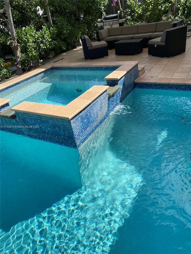 view of pool with an outdoor living space, a patio area, and a pool with connected hot tub