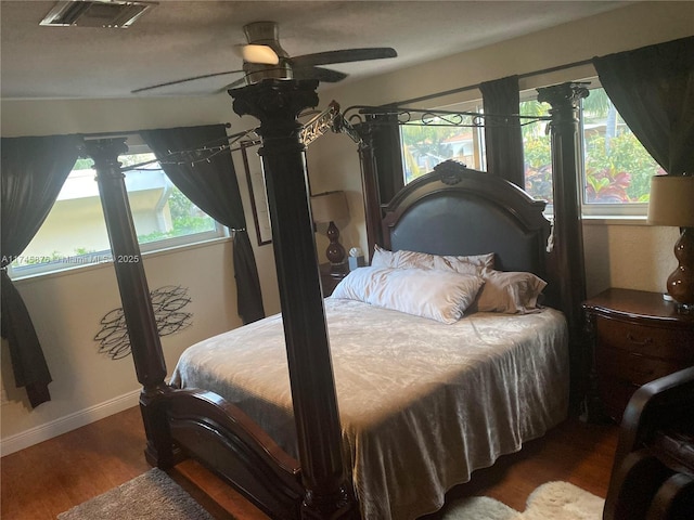 bedroom with baseboards, wood finished floors, visible vents, and a ceiling fan