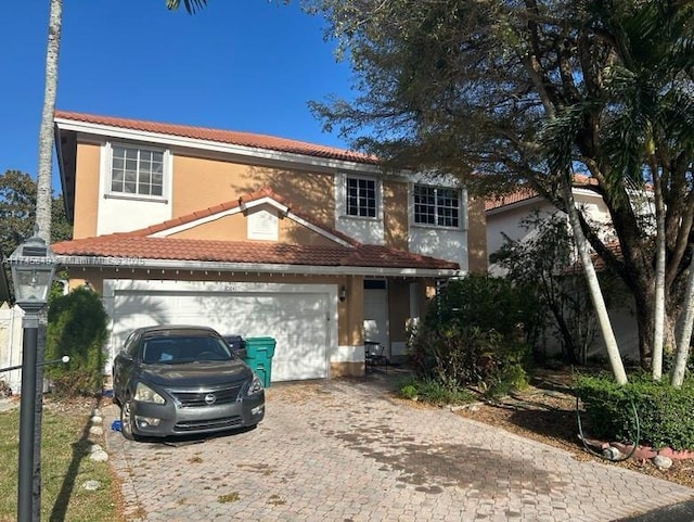 view of front of house featuring an attached garage, stucco siding, decorative driveway, and a tiled roof