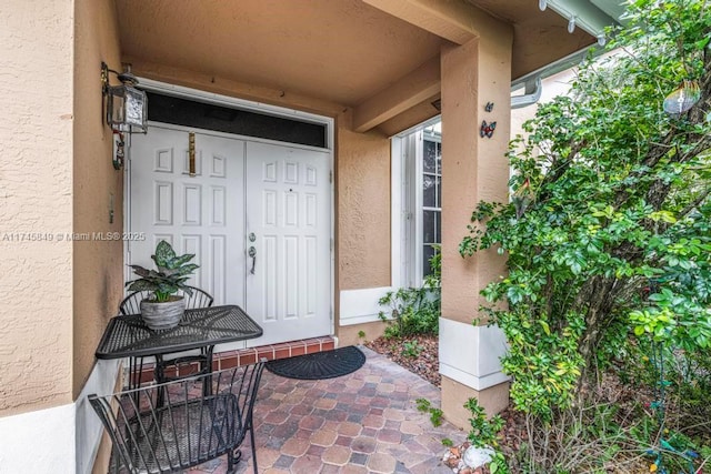 entrance to property featuring stucco siding