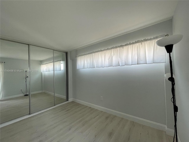 unfurnished bedroom featuring light wood-type flooring and a closet