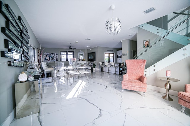 living room with ceiling fan with notable chandelier