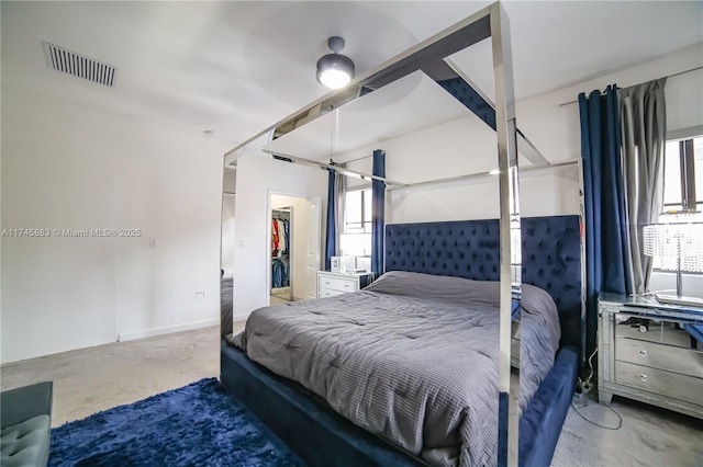 bedroom featuring a spacious closet, a closet, and ceiling fan