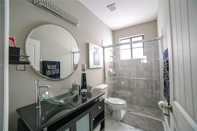 bathroom with a shower with door, vanity, and toilet