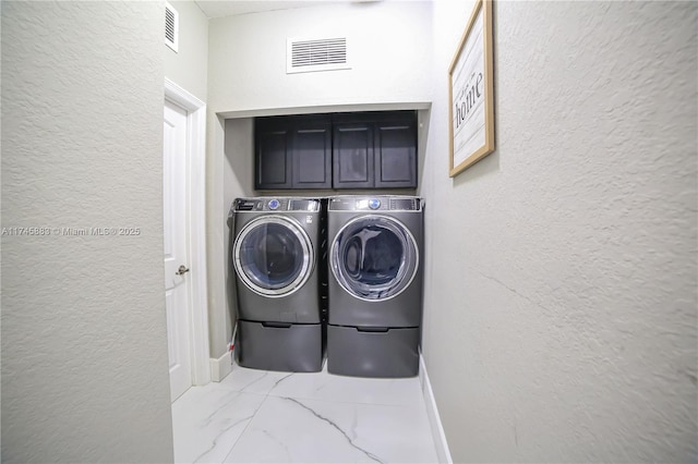 laundry room with cabinets and washer and dryer