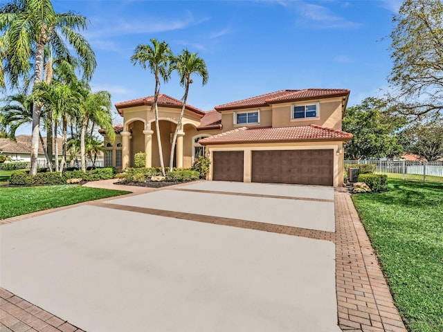 mediterranean / spanish-style home featuring a garage and a front yard