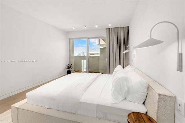 bedroom with access to outside and light wood-type flooring