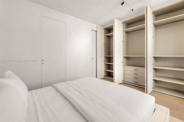 bedroom with multiple closets and light wood-type flooring