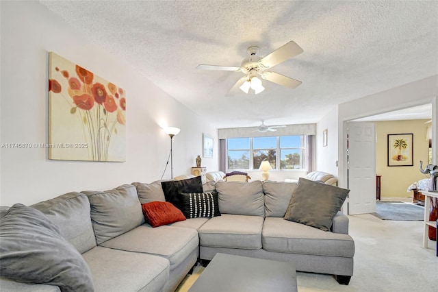 carpeted living room featuring ceiling fan and a textured ceiling