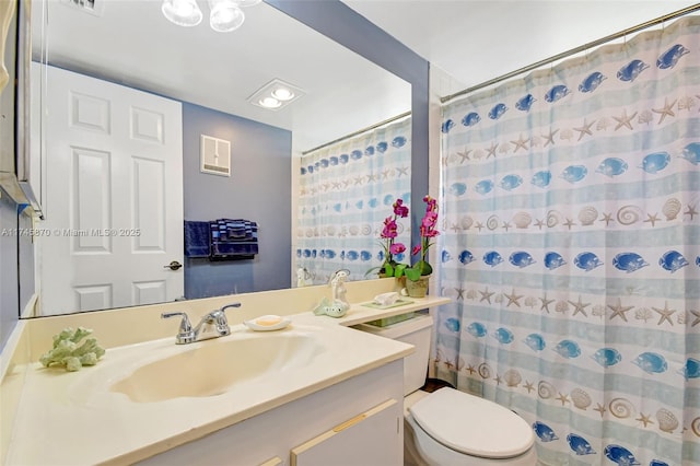 bathroom with vanity, curtained shower, and toilet