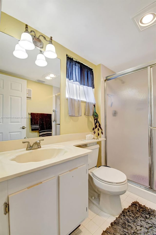 bathroom featuring tile patterned flooring, vanity, walk in shower, and toilet