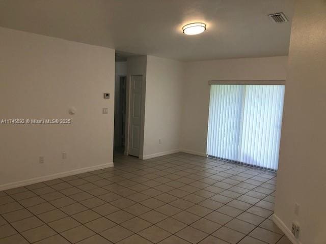 spare room with light tile patterned floors, baseboards, and visible vents