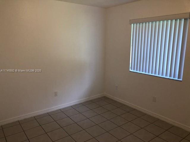 unfurnished room with baseboards