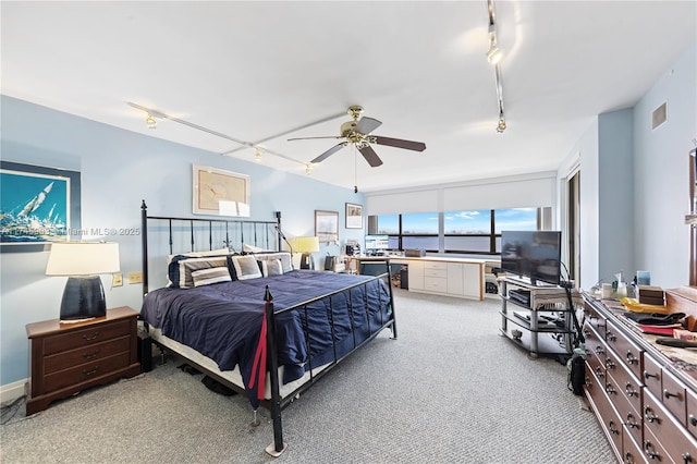 bedroom with ceiling fan, light colored carpet, and rail lighting