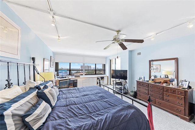 carpeted bedroom with ceiling fan and rail lighting