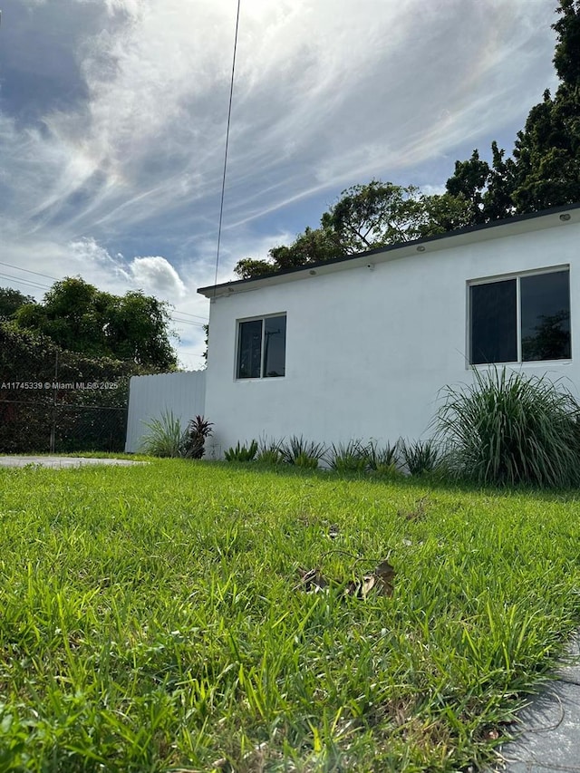 view of property exterior featuring stucco siding and fence