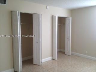 unfurnished bedroom featuring multiple closets