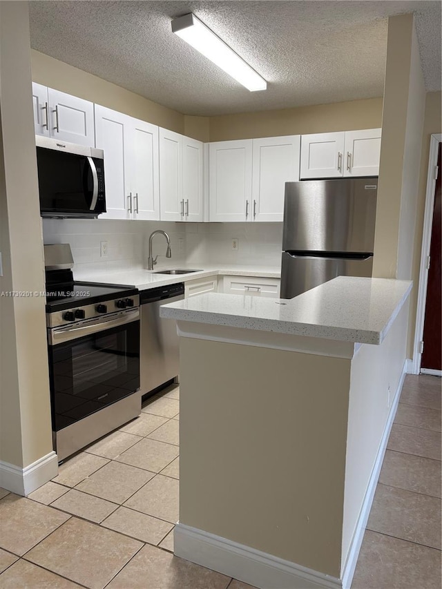 10717 Cleary Blvd Unit 203, Plantation, FL 33324 - kitchen with a sink, white cabinetry, baseboards, a textured ceiling, and appliances with stainless steel finishes