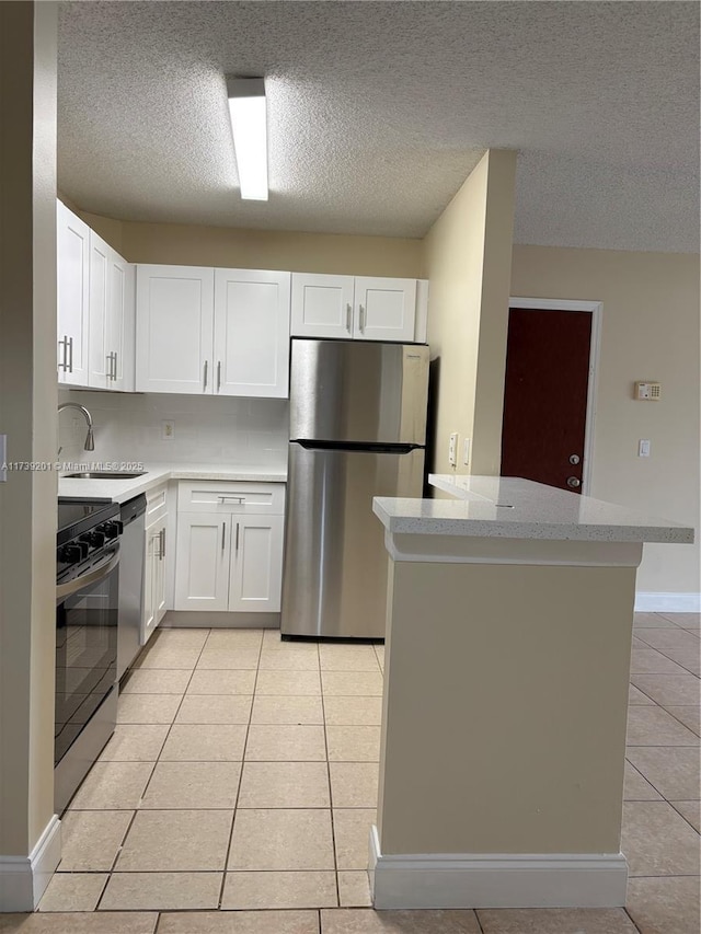 10717 Cleary Blvd Unit 203, Plantation, FL 33324 - kitchen featuring a sink, light tile patterned floors, a textured ceiling, white cabinets, and appliances with stainless steel finishes