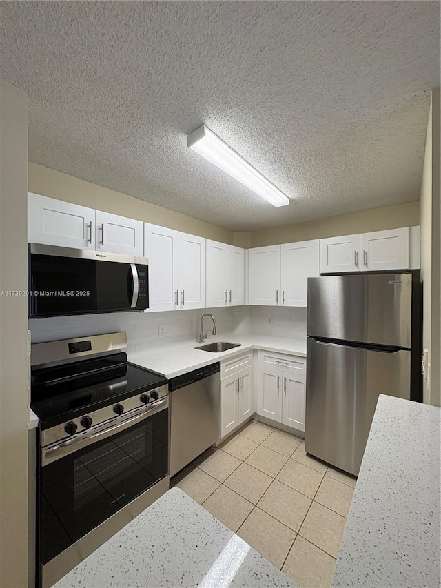 10717 Cleary Blvd Unit 203, Plantation, FL 33324 - kitchen featuring light tile patterned floors, white cabinetry, a sink, appliances with stainless steel finishes, and light countertops