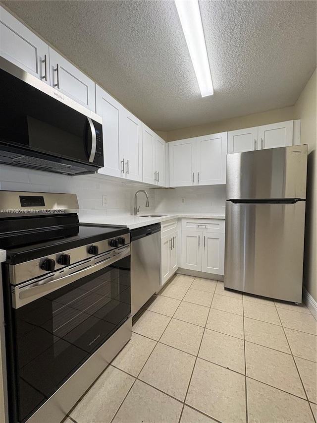 10717 Cleary Blvd Unit 203, Plantation, FL 33324 - kitchen with a textured ceiling, light tile patterned floors, white cabinets, stainless steel appliances, and light countertops