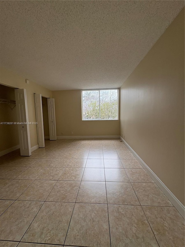 10717 Cleary Blvd Unit 203, Plantation, FL 33324 - unfurnished room featuring a textured ceiling, light tile patterned floors, and baseboards
