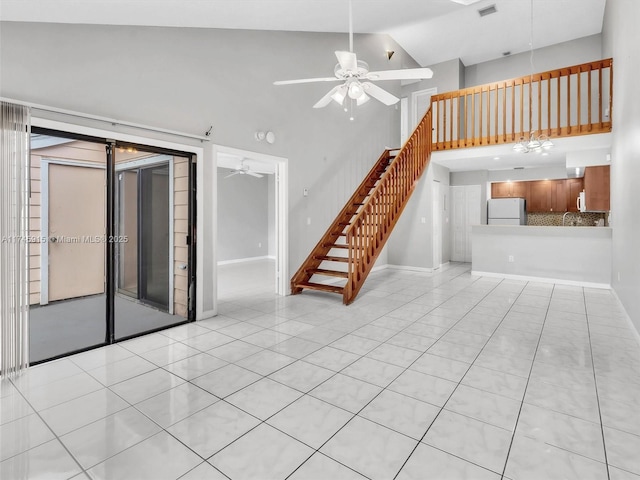 unfurnished living room with high vaulted ceiling, ceiling fan, and light tile patterned flooring