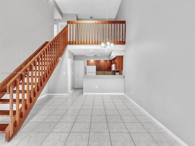 unfurnished living room with light tile patterned floors and a high ceiling