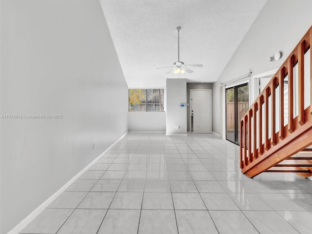 foyer entrance with lofted ceiling, light tile patterned floors, a textured ceiling, and ceiling fan