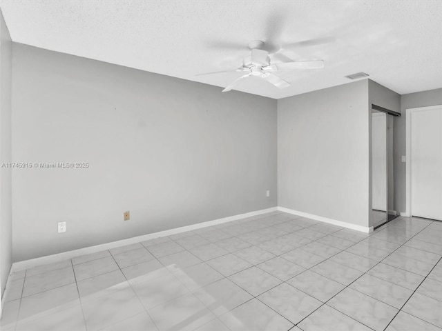 spare room with a barn door, a textured ceiling, and ceiling fan