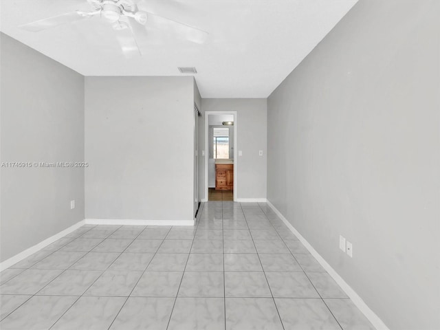 tiled empty room featuring ceiling fan