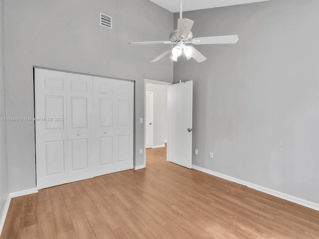 unfurnished bedroom with ceiling fan, a closet, and light hardwood / wood-style flooring