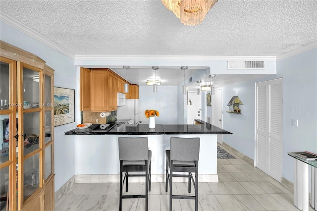 1020 Meridian Ave Unit 515, Miami Beach, FL 33139 - kitchen with dark countertops, white appliances, a peninsula, ornamental molding, and visible vents