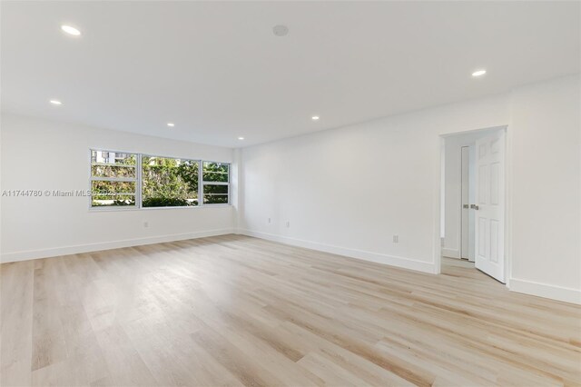 spare room with baseboards, recessed lighting, and light wood-type flooring