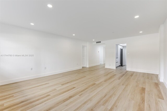 unfurnished room featuring baseboards, visible vents, recessed lighting, and light wood-type flooring