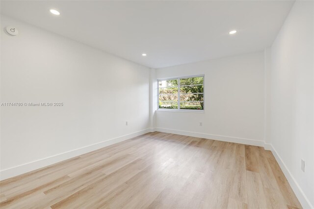 unfurnished room featuring baseboards, light wood-style flooring, and recessed lighting