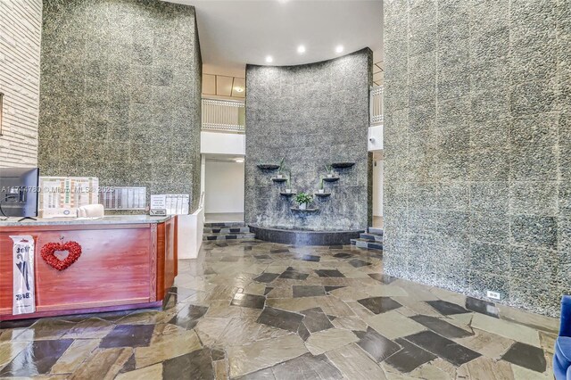 interior space featuring stone finish floor and a towering ceiling