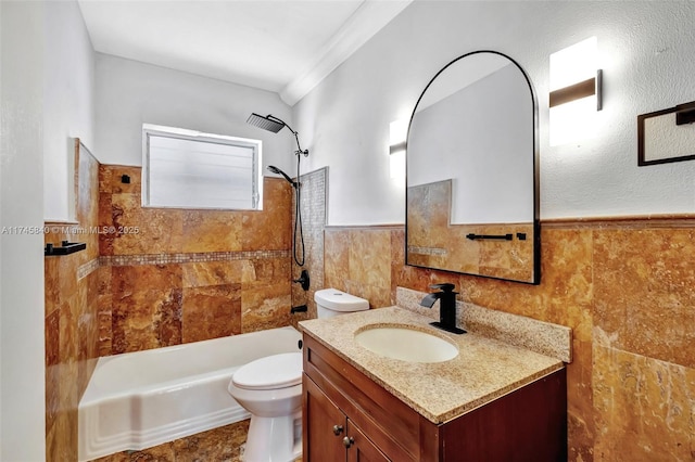 full bathroom with tile walls, vanity, tiled shower / bath combo, and toilet